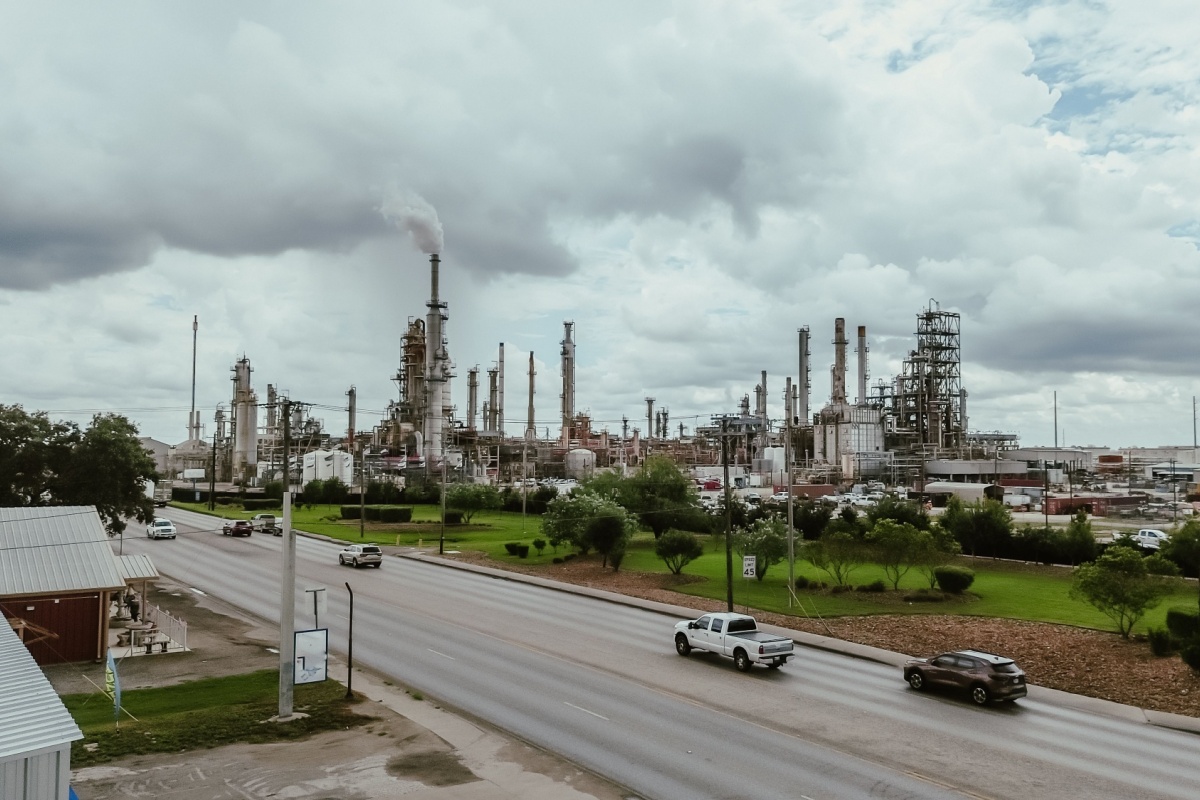 Aerial view highway near large oil refinery complex plant with gas flare, crude oil distillation unit, storage tanks, utility systems, pipelines in rural agriculture agro-town San Antonio, Texas. USA