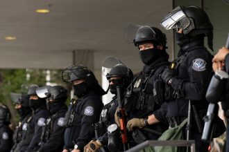 U.S. Customs and Border Protection (CBP) field officers guard a federal building during ICE deportation protests in Downtown LA.